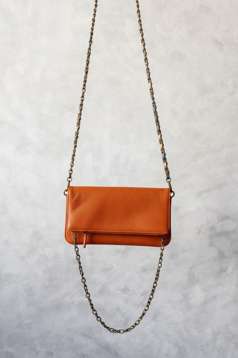 Bolso de piel naranja con dos cadenas