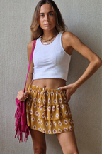 Minifalda pantalón estampada y volantes mostaza