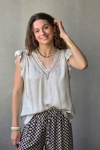 Blusa beige raso con puntilla y volante en la manga