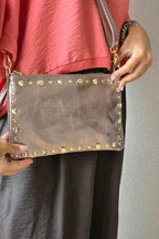 Bolso de piel tipo sobre con tachas cobre