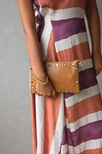 Bolso de piel tipo sobre con tachas camel