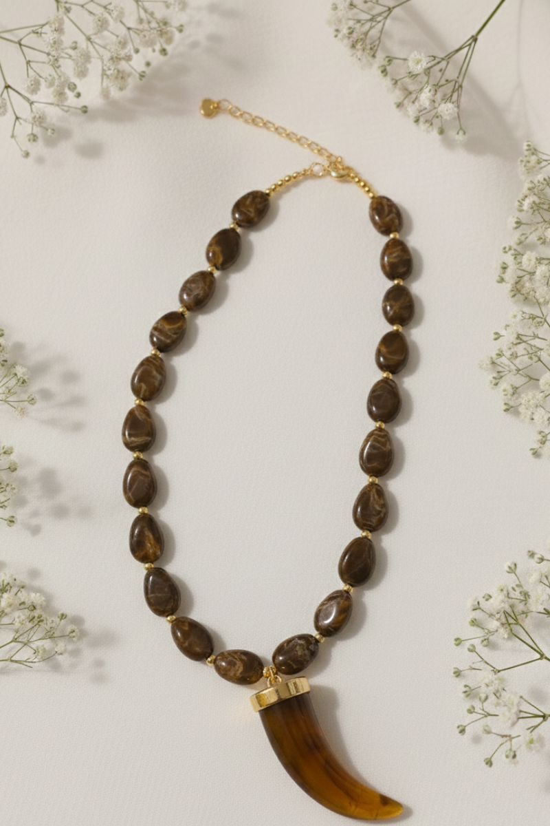 Collar de acero y cuerno en piedras marrón