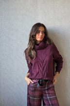 Jersey cuello cisne con con trenza berenjena