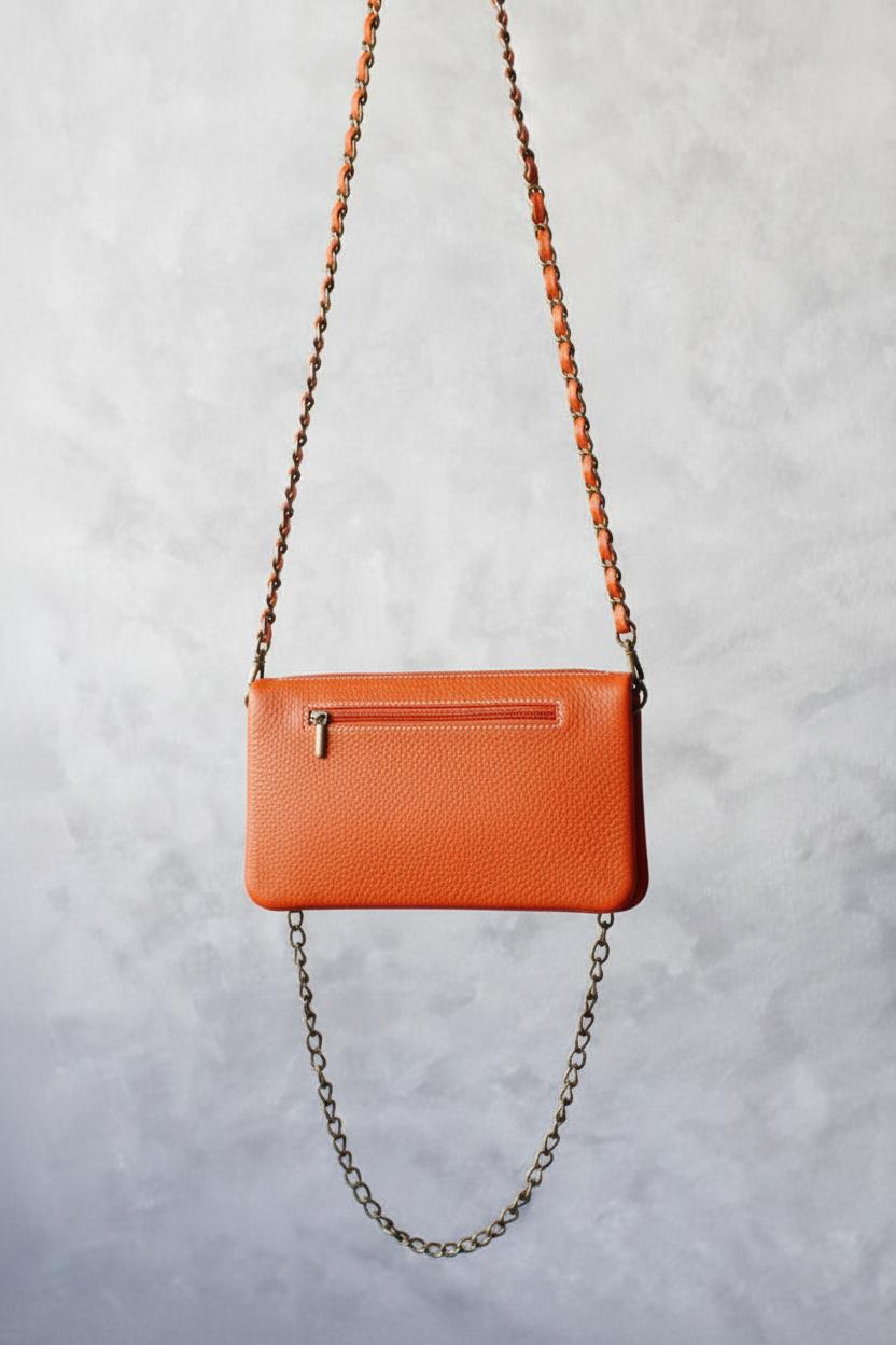Bolso de piel naranja con dos cadenas