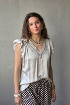 Blusa beige raso con puntilla y volante en la manga