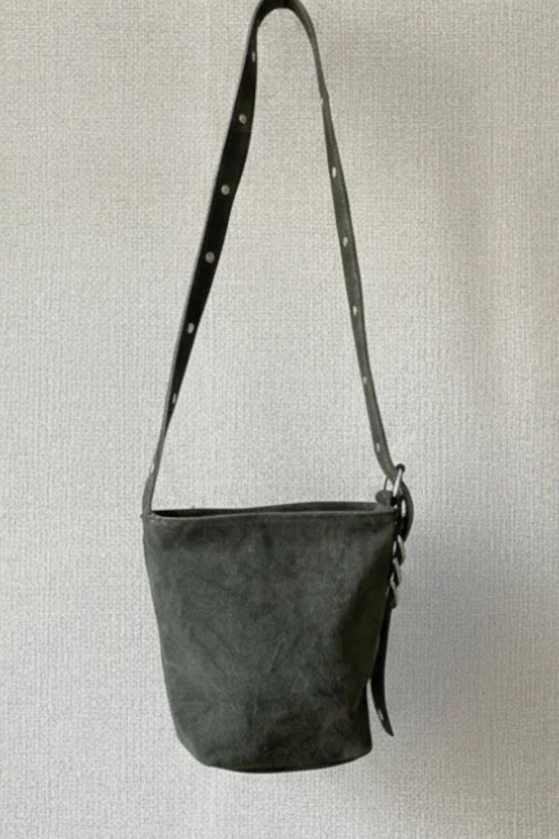 Bolso tipo ante verde militar con tachas en el asa