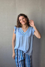 Blusa celeste raso con puntilla y volante en la manga