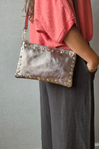 Bolso de piel tipo sobre con tachas cobre