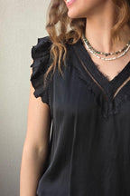Blusa negro raso con puntilla y volante en la manga