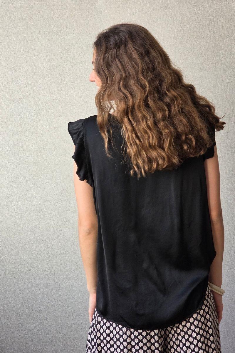 Blusa negro raso con puntilla y volante en la manga