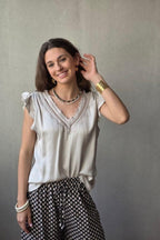 Blusa beige raso con puntilla y volante en la manga
