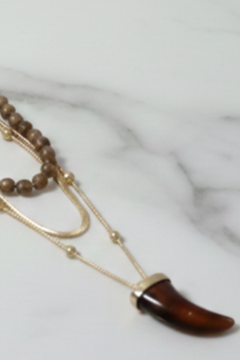  Detalle del collar triple de cuerno y acabado dorado