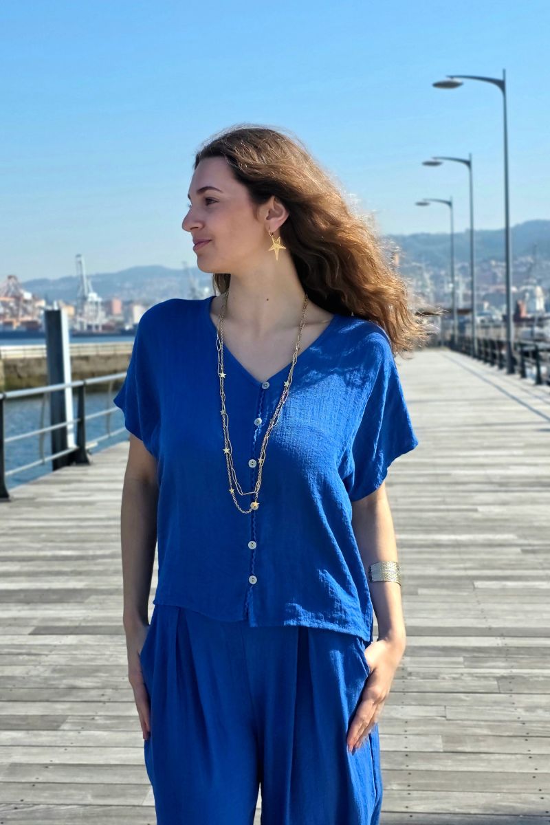 Blusa de botones en tono azulón, tejido ligero y transpirable. Estilo casual-chic, fácil de combinar. Envío desde España.
