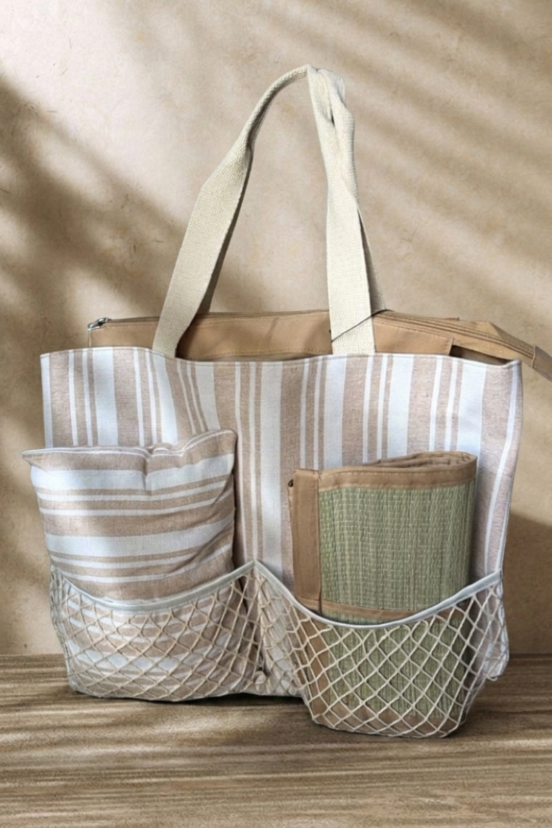 Bolsa de playa con cojín y esterilla integrados. Diseño de rayas resistente y práctico. Disponible en gris y camel. Todo en uno para tus días de verano.