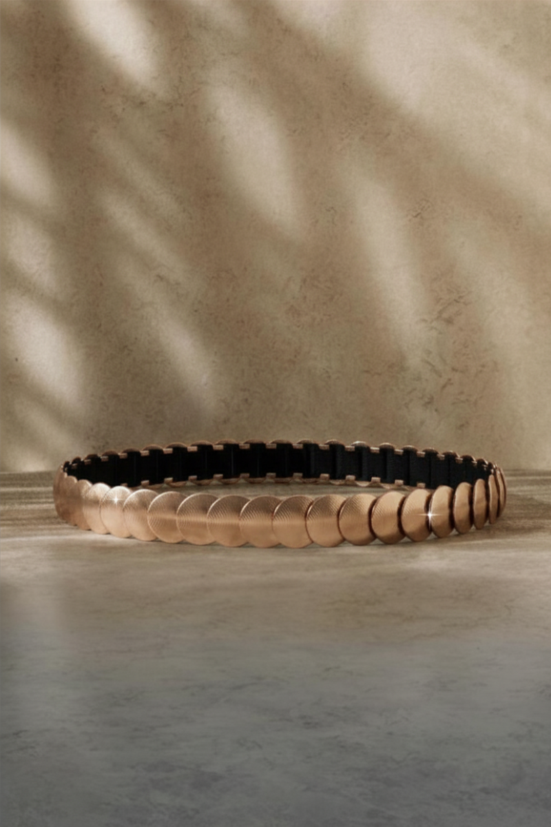 Cinturón con círculos dorados tipo chapas y elástico negro. Diseño único, cómodo y elegante