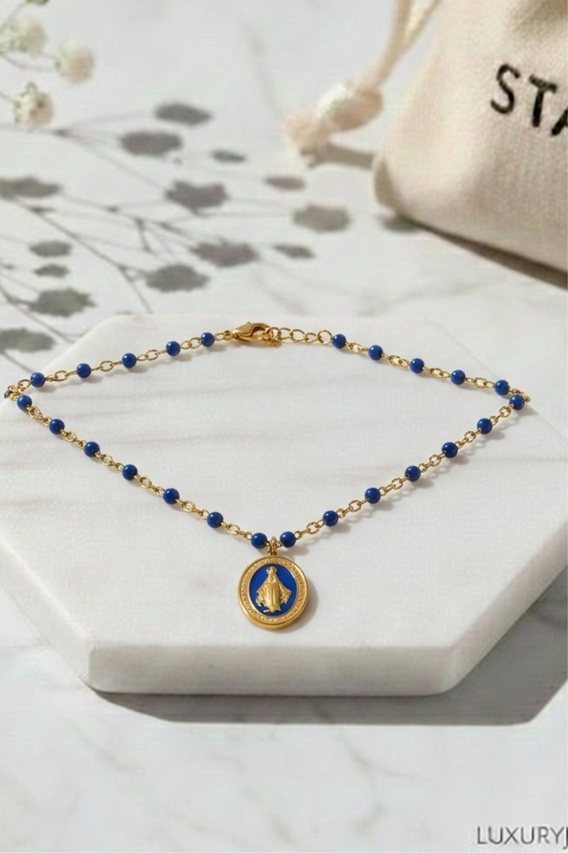 Detalle de medalla virgen en gargantilla dorada de acero inoxidable