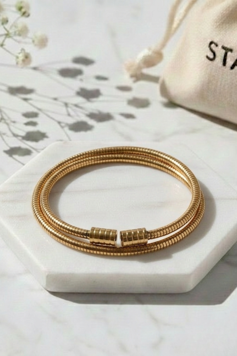 Pulsera doble tipo muelle dorada de acero inoxidable con diseño flexible y envolvente
