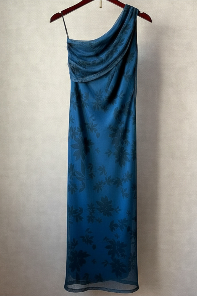 Vestido estampado de flores con escote hombro descubierto en tono azul. Tejido fluido, femenino y lleno de color. Perfecto para eventos y verano.