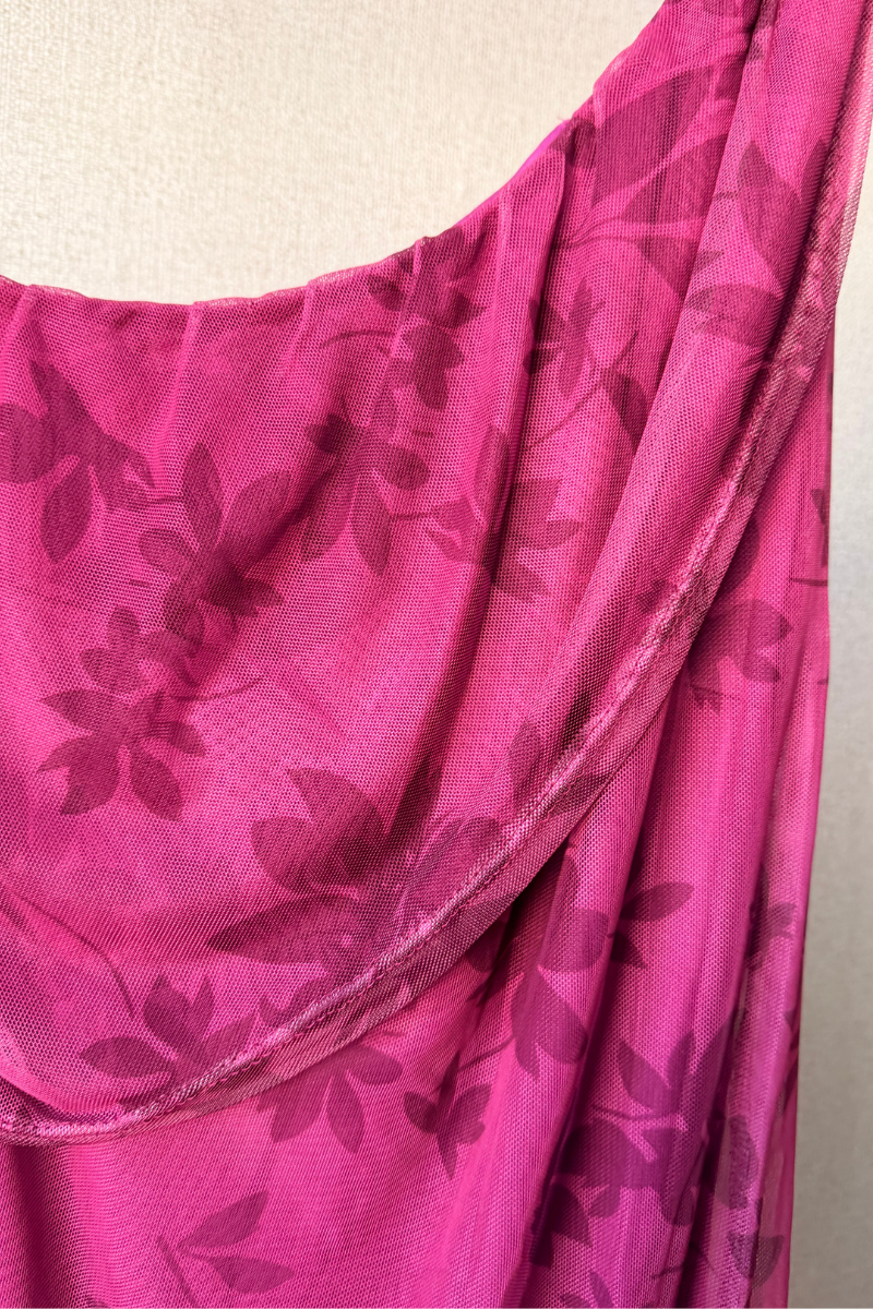 Vestido estampado de flores con escote hombro descubierto en tono buganvilla. Tejido fluido, feminino y lleno de color. Perfecto para eventos y verano.