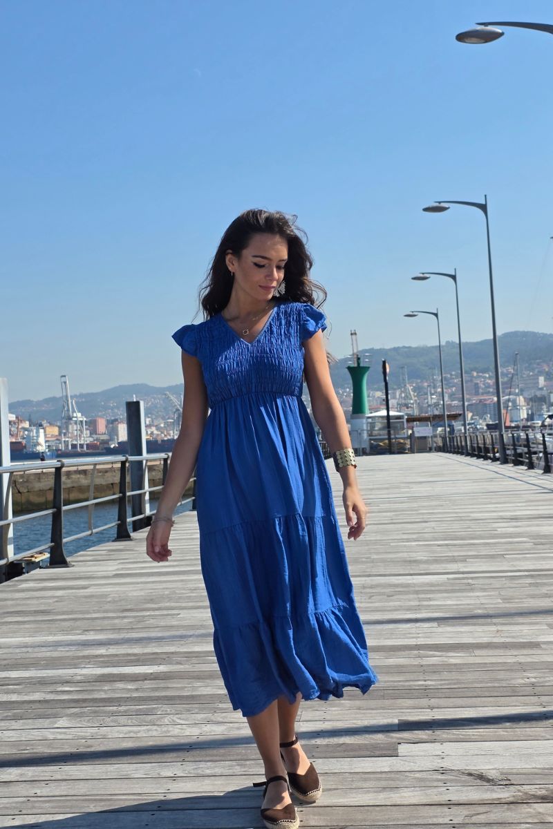 Vestido largo azulón con fruncido, escote en pico y volantes en manga y falda. Elegante y femenino. Envío desde España.