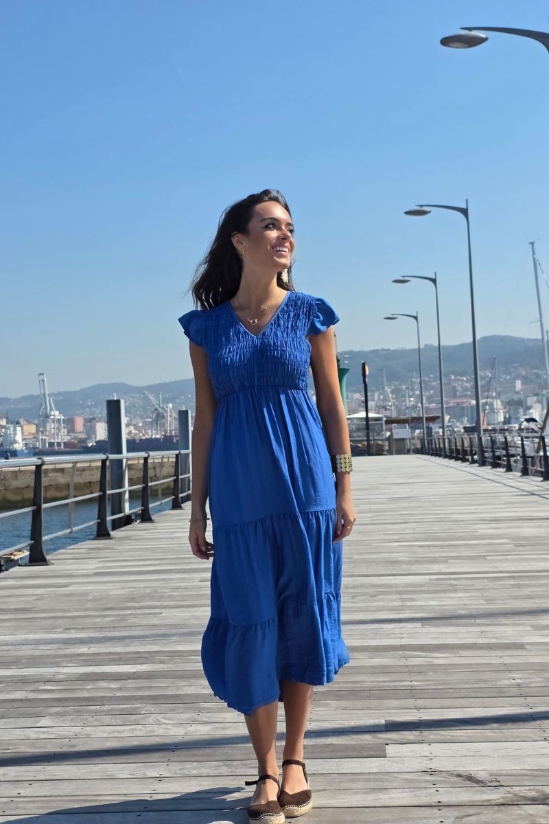 Vestido largo azulón con fruncido, escote en pico y volantes en manga y falda. Elegante y femenino. Envío desde España.