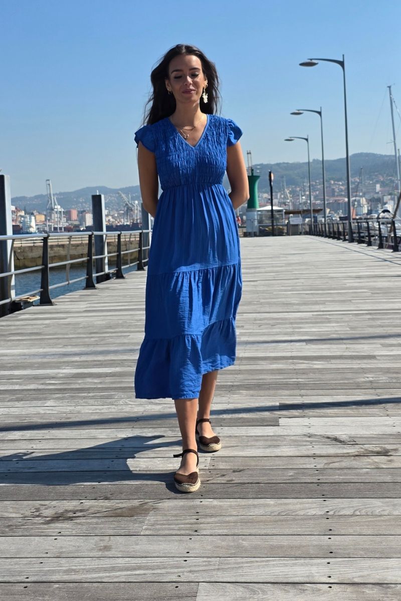 Vestido largo azulón con fruncido, escote en pico y volantes en manga y falda. Elegante y femenino. Envío desde España.