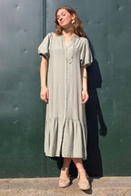 Vestido caqui de manga globo con botones y volantes en el bajo. Elegante y femenino, perfecto para eventos y ocasiones especiales. Descúbrelo en Liberatta.