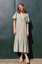 Vestido caqui de manga globo con botones y volantes en el bajo. Elegante y femenino, perfecto para eventos y ocasiones especiales. Descúbrelo en Liberatta.